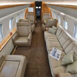 Interior of Bombardier Challenger 605 cabin with beige seating area and sofa